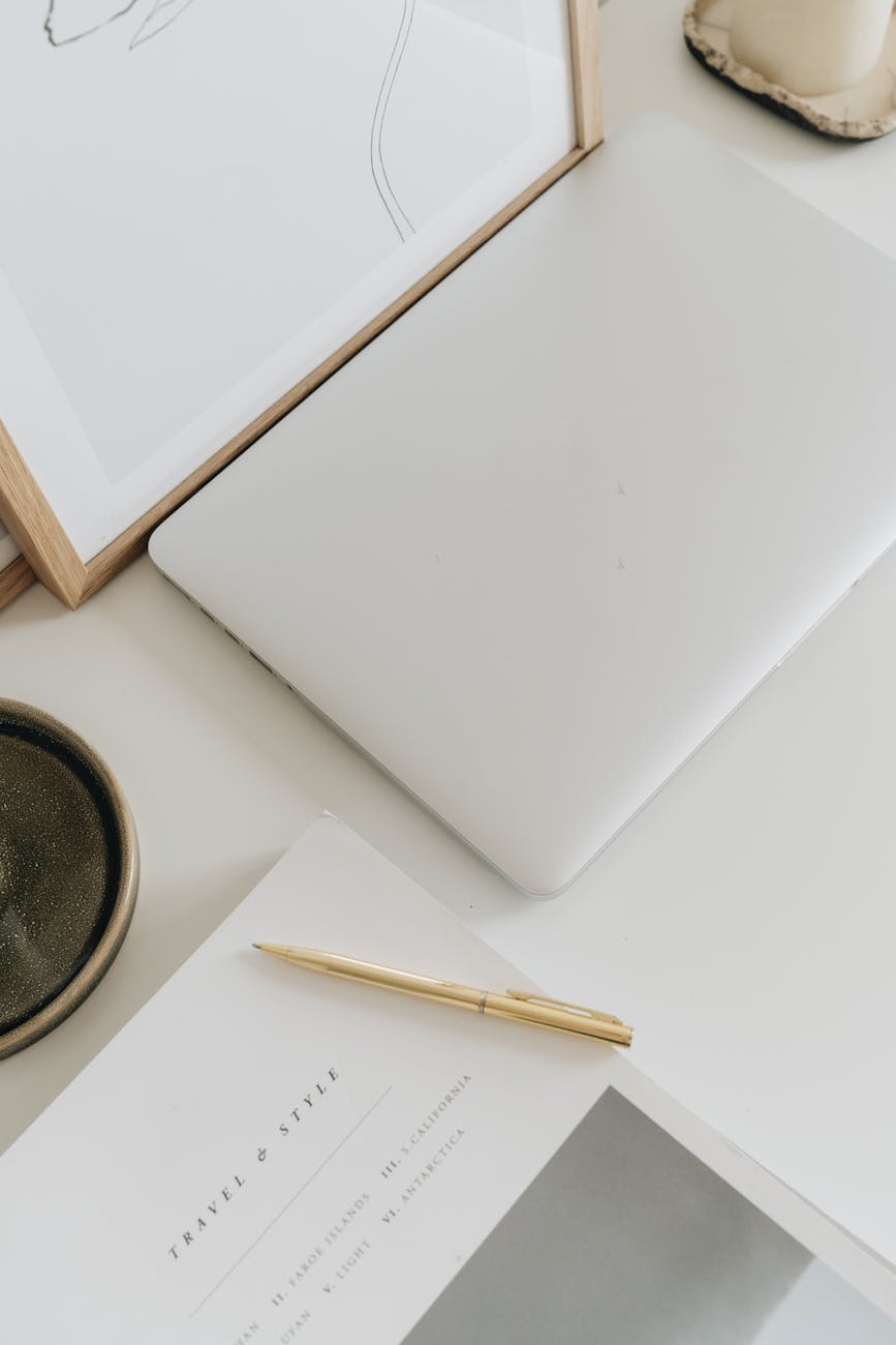 golden pen near closed laptop